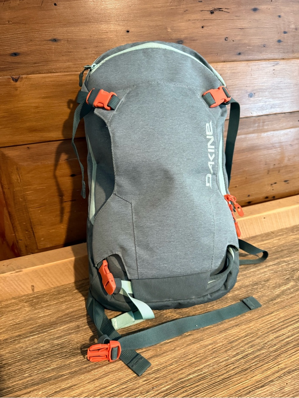 Dakine Mint tinted heli pack 12 backpack with Orange Buckles